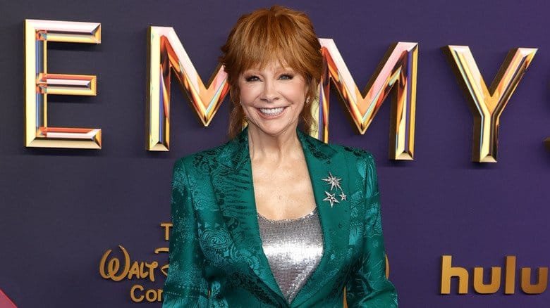 Reba McEntire wearing a teal and silver suit