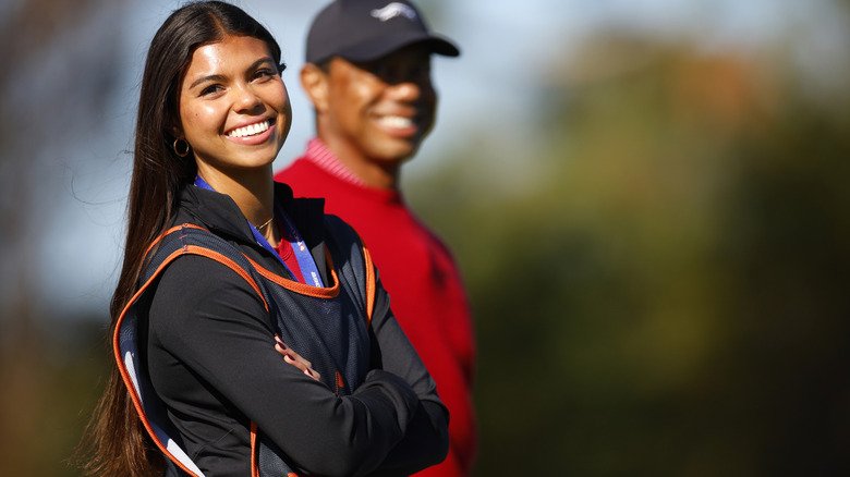 Sam Woods smiles for cameras while standing alongside Tiger Woods.