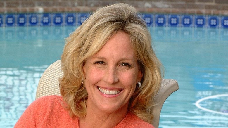 Erin Brockovich smiling beside a pool