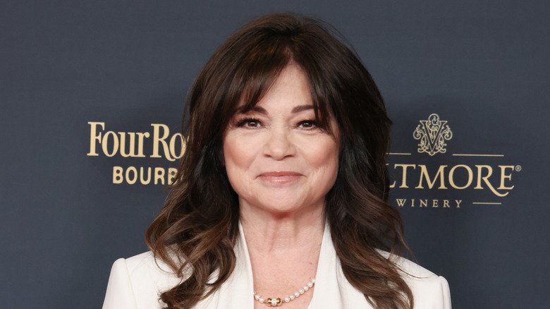 Valerie Bertinelli smirking wearing white suit