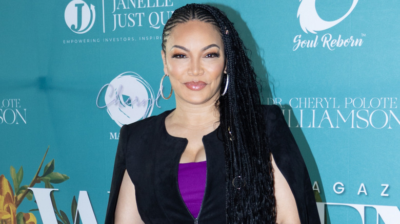 Egypt Sherrod wearing a purple dress and cape