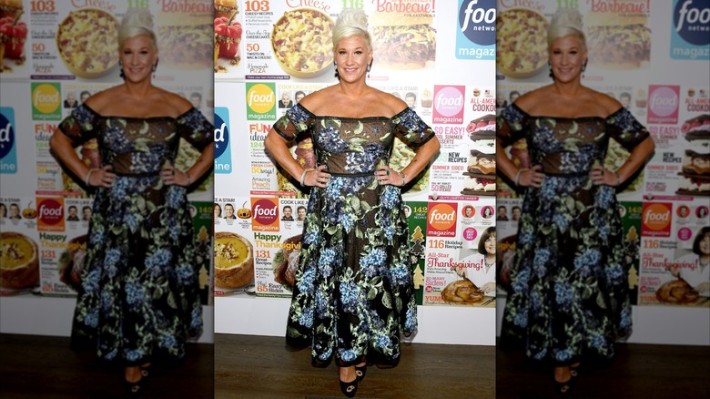 Anne Burrell posing in a black floral-print dress