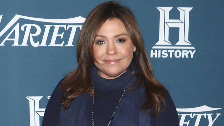Rachael Ray posing in a scarf and dark colored outfit