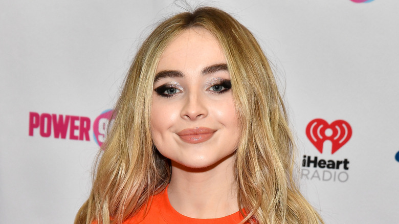 Sabrina Carpenter smiles for photographers at the 2018 Jingle Ball