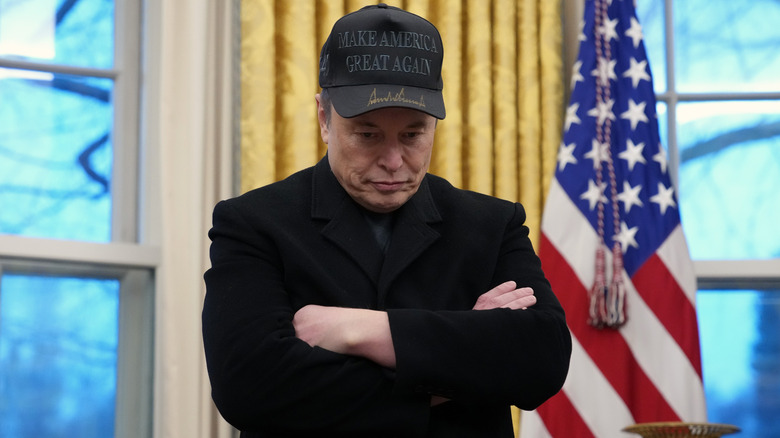 Elon Musk wearing a black MAGA cap at the Oval Office.